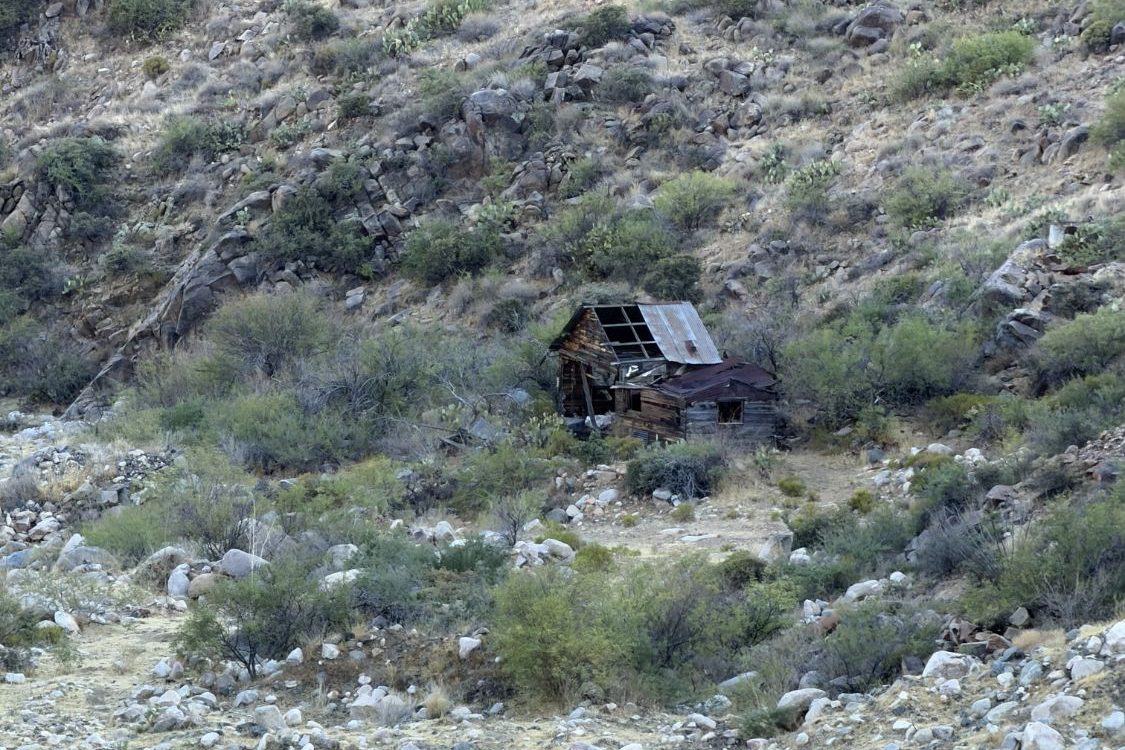 A weathered miner's cabin on a boulder-strewn Arizona hillside